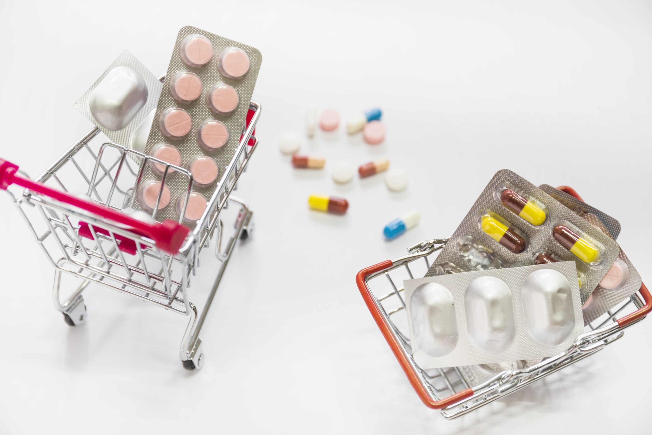 pills-medicine-blisters-inside-two-shopping-cart-white-background