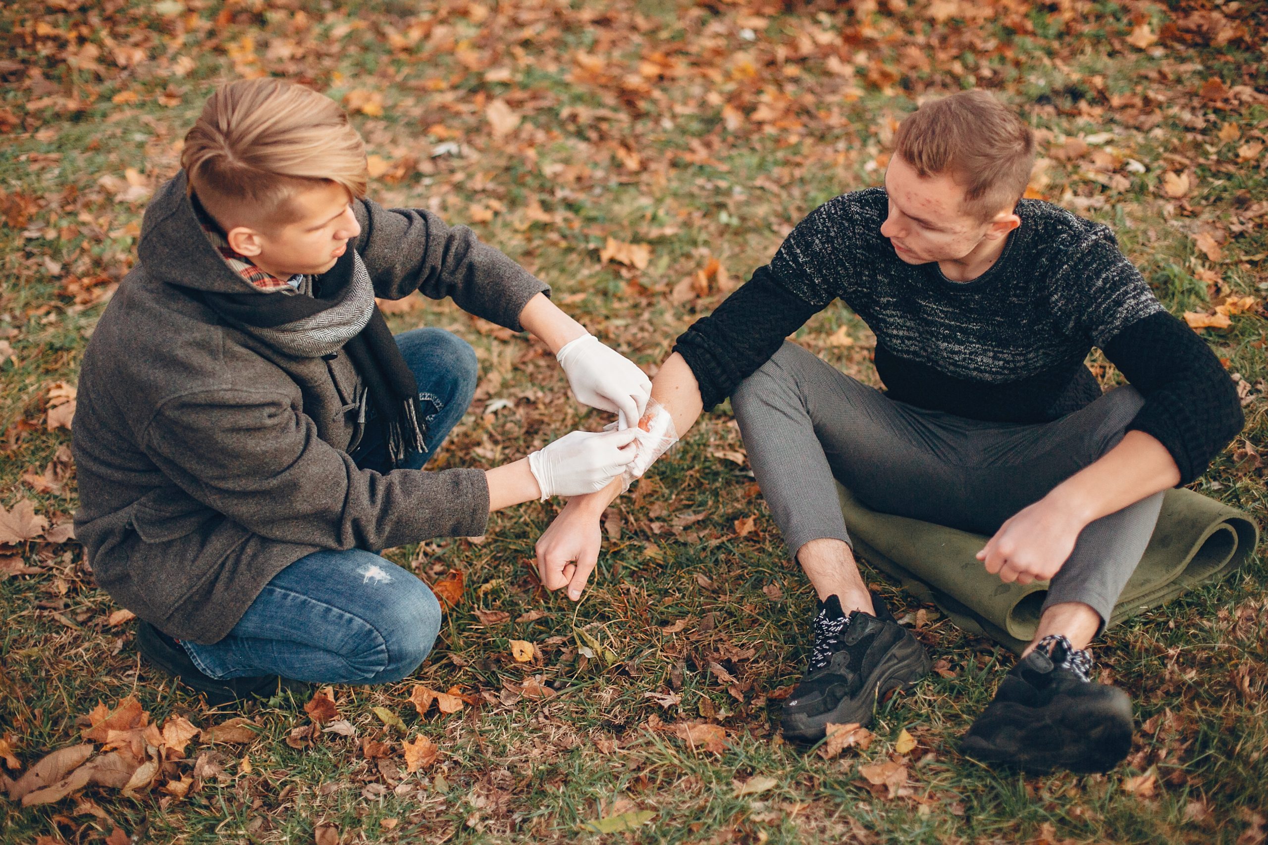 Guy bandages his friend's hand